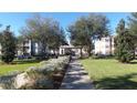 Sidewalk shot of the landscaped community including buildings, sidewalks, and green spaces at 6412 Queens Borough Ave # 109, Orlando, FL 32835