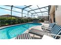 Relaxing screened-in pool area with comfortable lounge chairs and a hot tub, perfect for outdoor enjoyment at 8157 Fan Palm Way, Kissimmee, FL 34747
