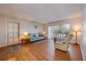 Living room featuring hardwood floors, a large window for natural light, and comfortable seating at 8215 Sun Spring Cir # 32, Orlando, FL 32825