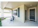 Covered front porch with outdoor seating next to the front door at 954 Laurel View Way, Groveland, FL 34736