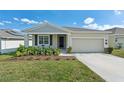 Charming single-story home featuring a well-maintained lawn and two-car garage at 954 Laurel View Way, Groveland, FL 34736