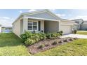 Landscaped front yard with green bushes and a view of the lake nearby at 954 Laurel View Way, Groveland, FL 34736