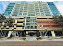 Street view of modern building showcasing balconies and 101 Eola address with street front dining at 101 S Eola Dr # 1208, Orlando, FL 32801