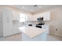 Bright kitchen featuring white cabinets, stainless steel appliances, and a central island at 1039 Morningside Dr, Eustis, FL 32726