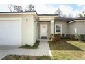 Inviting home exterior with an attached garage, a manicured lawn, and a well-lit entryway at 1090 Parnell Ct, Deltona, FL 32738