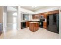 Efficient kitchen featuring granite countertops, dark cabinetry, black appliances, and a tiled floor at 113 Rockhill Dr, Sanford, FL 32771