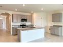 Modern kitchen with gray cabinets, granite countertops, and stainless steel appliances at 2877 Sunridge Loop, St Cloud, FL 34771