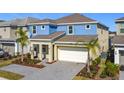 Charming two-story home with a two-car garage, featuring blue and beige paint, complemented by a well-kept front yard at 299 Marcello Blvd, Kissimmee, FL 34746