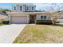 Charming two-story home with well-manicured lawn and a brick driveway at 34429 Alameda Dr, Sorrento, FL 32776