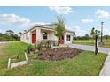 A view of single-Gathering home featuring stone accents, a well-manicured lawn and a gray paved driveway at 3495 Salvia Ct, Tavares, FL 32778