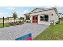 Single-Gathering home featuring stone accents, a well-manicured lawn and a gray paved driveway at 3495 Salvia Ct, Tavares, FL 32778