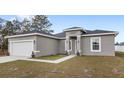 Well-maintained single-Gathering home featuring a two-car garage, manicured lawn, and covered entryway at 42 Willow Ln, Poinciana, FL 34759
