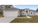 Charming single-story home featuring a white garage door, neutral paint, and a well-manicured lawn at 42 Willow Ln, Poinciana, FL 34759