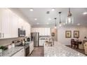 Modern kitchen with white cabinets, stainless steel appliances, and a large granite island at 421 W Ariel Rd, Edgewater, FL 32141