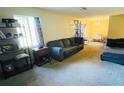 Spacious living room featuring carpet flooring, a couch, and a dining area at 4759 S Texas Ave # 4759C, Orlando, FL 32839