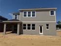 Rear view of a two-story home featuring a gray exterior, windows, and a covered porch at 726 Pointe Emerson Blvd, Apopka, FL 32703
