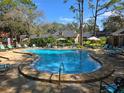 Community pool surrounded by lounge chairs and umbrellas, offering a refreshing oasis at 940 Douglas Ave # 132, Altamonte Springs, FL 32714
