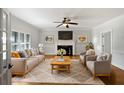 Cozy living room with a fireplace, ceiling fan, and ample seating for a comfortable gathering space at 112 Woden Way, Winter Haven, FL 33884