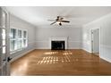 Bright, spacious living room featuring hardwood floors, a fireplace, and natural light from the large window at 112 Woden Way, Winter Haven, FL 33884