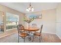 Bright dining area with a window, a chandelier and beach art hanging on the wall at 114 Alexandria Cir, Deland, FL 32724