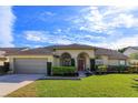 Inviting single-story home boasts arched entryway, well-kept lawn, and convenient two-car garage at 11554 Blackmoor Dr, Orlando, FL 32837