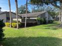 View of the home's exterior surrounded by beautiful green landscaping with trees at 1200 Winterberry Lane, Fern Park, FL 32730