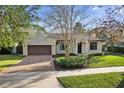 Inviting single-story home with a brick driveway, lush lawn, and a charming terracotta-tiled roof at 1690 Oneco Ave, Winter Park, FL 32789