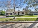 Beautiful single-story home featuring a well-manicured lawn, brick driveway, and a classic terracotta tile roof at 1690 Oneco Ave, Winter Park, FL 32789