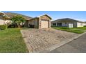 Single-Gathering home with a paver driveway, mature landscaping and a stone accent garage at 1821 Christina Lee Ln, St Cloud, FL 34769