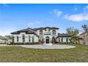 Stunning two-story home boasting manicured landscaping, circular driveway, and elegant architectural details at 3037 Seigneury Dr, Windermere, FL 34786