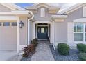 Inviting home entrance with a brick walkway, manicured bushes, and a 2 car garage on the side at 3202 Condrey Ct, The Villages, FL 32163