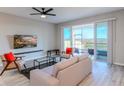 Bright living room with stylish furniture, ceiling fan, and sliding glass doors to an outdoor patio at 367 Sofia Ln, Lake Alfred, FL 33850