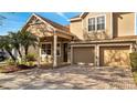 Well-maintained two-story home with a cozy front porch, and an attached two-car garage with brick driveway at 4019 Alcott Cir, Orlando, FL 32828