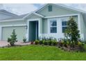Landscaped front yard with lush green lawn, colorful flowers, and a charming entry at 5960 Vision Rd, St Cloud, FL 34771
