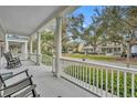 Charming front porch showcasing white railings and columns with views of the neighborhood at 610 Nadina Pl, Celebration, FL 34747