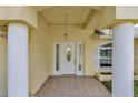 Home's elegant front entrance features stately columns and decorative leaded glass sidelights and transom at 700 Roby Ct, Dundee, FL 33838