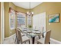 Elegant dining room with a glass table, chandelier lighting, and large windows at 7624 Bay Port Rd # 40, Orlando, FL 32819