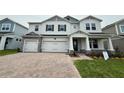 Beautiful two-story home featuring a brick paver driveway and a three-car garage at 780 Pointe Emerson Blvd, Apopka, FL 32703