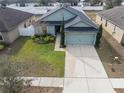 Charming home featuring a two-car garage, well-maintained lawn, and mature landscaping at 1230 Woodlark Dr, Haines City, FL 33844