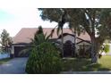 Charming single-story home featuring a well-maintained lawn, mature landscaping, and a two-car garage at 12017 Fambridge, Orlando, FL 32837