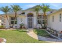 A lovely home's front entrance with a well-manicured lawn and desert plants at 1646 Arash Cir, Port Orange, FL 32128