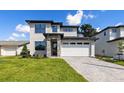 Contemporary two-story home featuring stone accents, a brick driveway, and a spacious two-car garage at 1807 Simonton Ave, Orlando, FL 32806