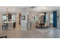 Open-concept dining area with elegant chandelier, tile floors, and access to the kitchen at 25850 Crossings Bluff Ln, Sorrento, FL 32776