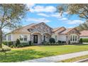 Charming one-story home with well-maintained lawn, stone accents, and manicured shrubbery at 25850 Crossings Bluff Ln, Sorrento, FL 32776