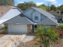 Charming home featuring a brick-accented facade, a well-manicured lawn, and a two-car garage at 3275 Windy Wood Dr, Orlando, FL 32812