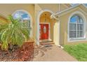 Close up of the elegant red front door with decorative glass and brick paver walkway at 477 Bohannon Blvd, Orlando, FL 32824