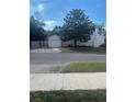 View of a detached garage with a white exterior and tree providing shade in the backyard at 48 E Par St, Orlando, FL 32804
