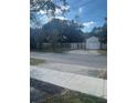 Home's front yard is surrounded by a white metal fence and has an attached garage at 48 E Par St, Orlando, FL 32804