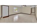 Inviting living room featuring tile floors, a ceiling fan, and a bright window, creating a warm atmosphere at 4804 Beacon St, Orlando, FL 32808