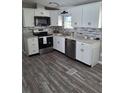 Updated kitchen featuring stainless steel appliances, granite countertops, and wood-look flooring at 50989 Highway 27 # 105, Davenport, FL 33897